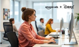 Imagen de una mujer de unso 30 años, blanca y de pelo corto castaño, que está trabajando en su ordenador en el interior de una oficina luminosa.