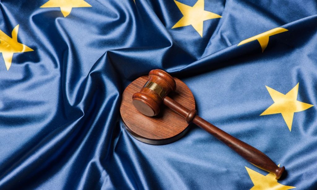 Fotografía de un mazo de justicia colocado sobre una bandera de la Unión Europea